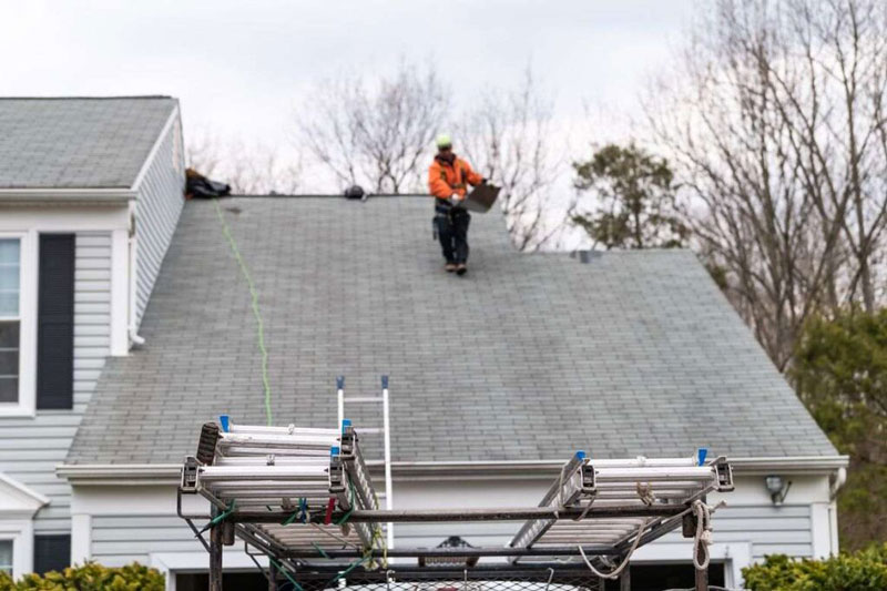 A man is working on a house roof in Orlando, FL